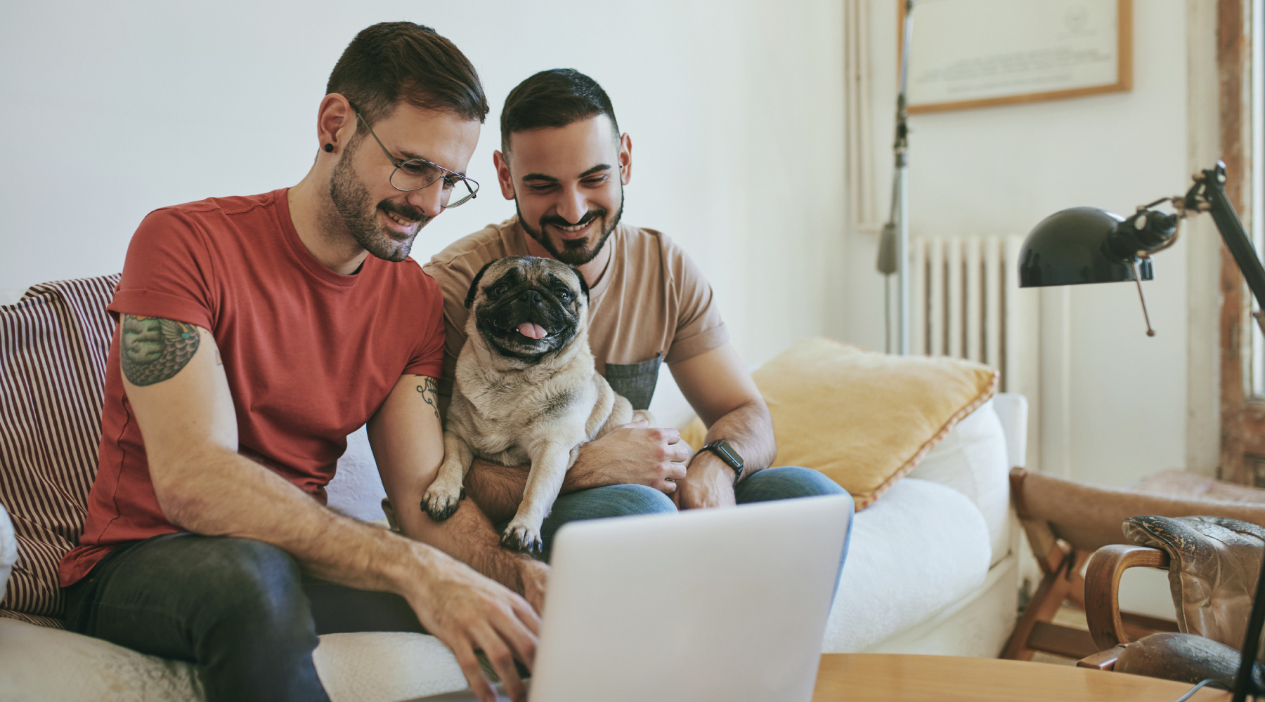 LGBTQ Couple looking at computer with their pug