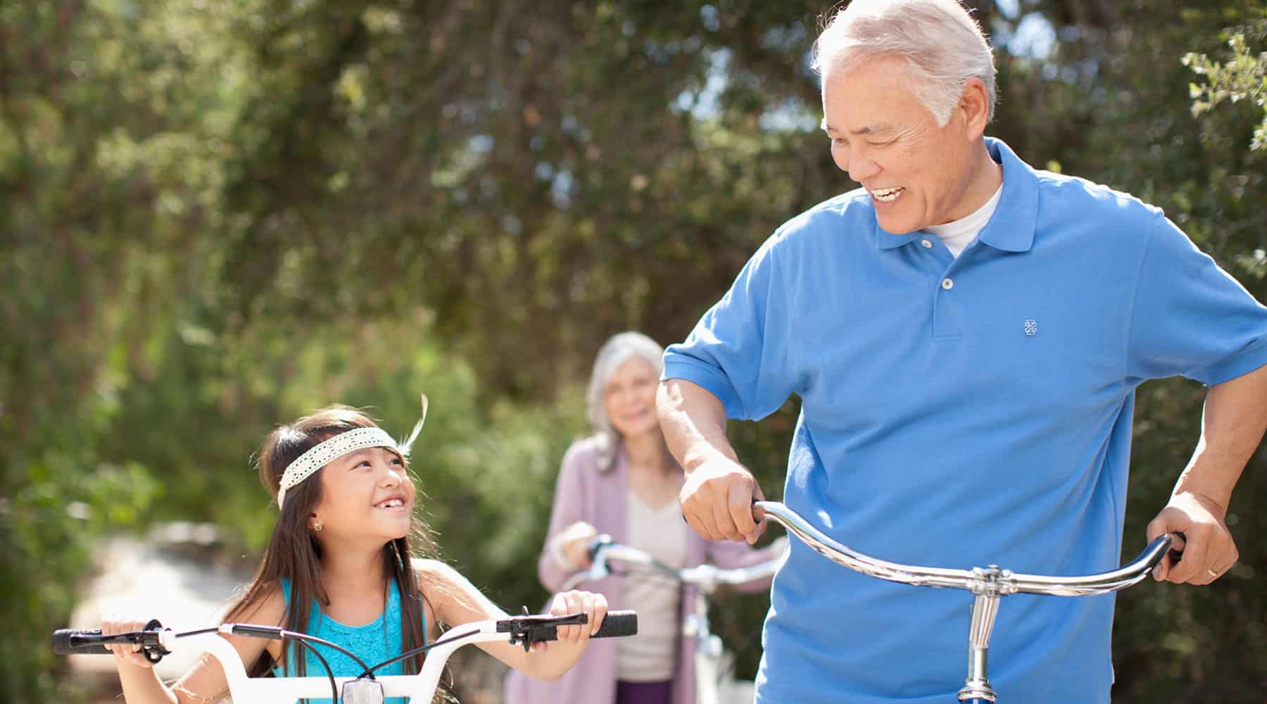 Grandparents riding bikes with their granddaughter