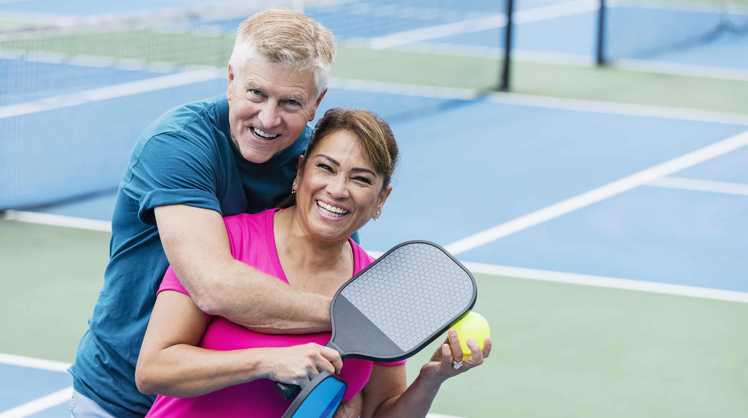 Senior married couple playing pickleball