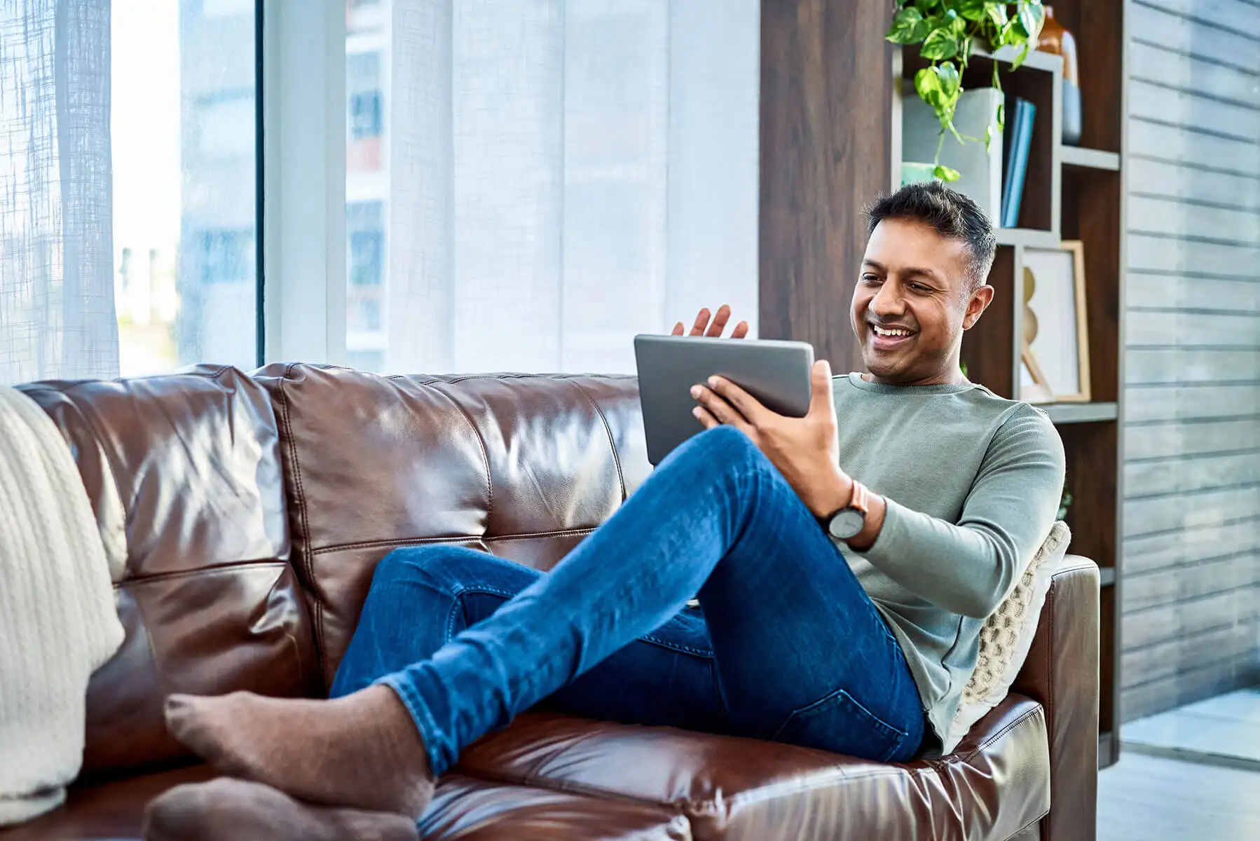 Man on couch looking at a tablet