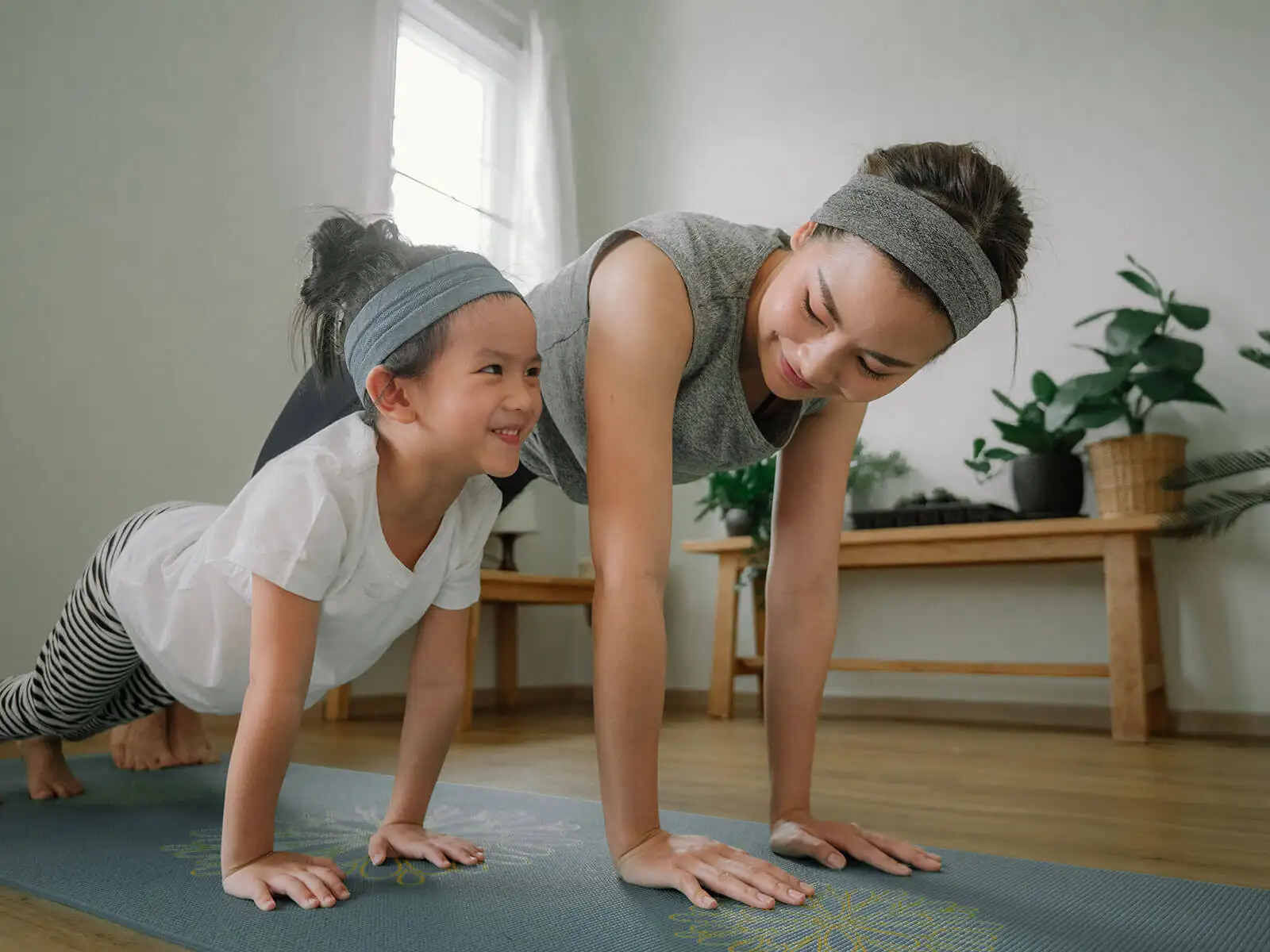 Mother and daughter in fitness clothing, planking